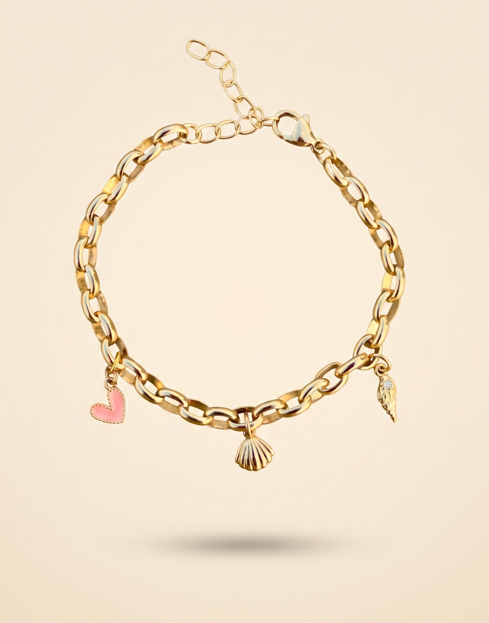 Gold chain bracelet with heart and shell charms on a beige background